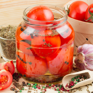 Stock Foto Tomatoes with bow for winter - recipes
